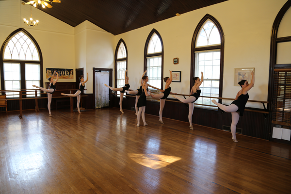a group of ballerinas are practicing in a dance studio