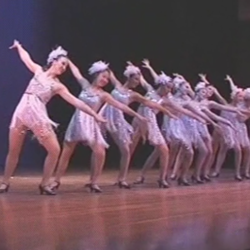 a group of young women are dancing on a stage .