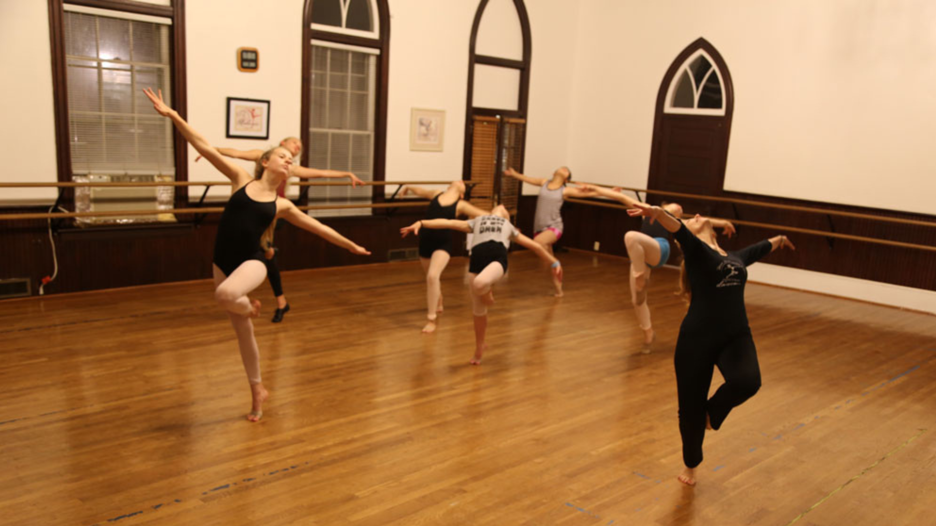 a group of young girls are dancing in a dance studio