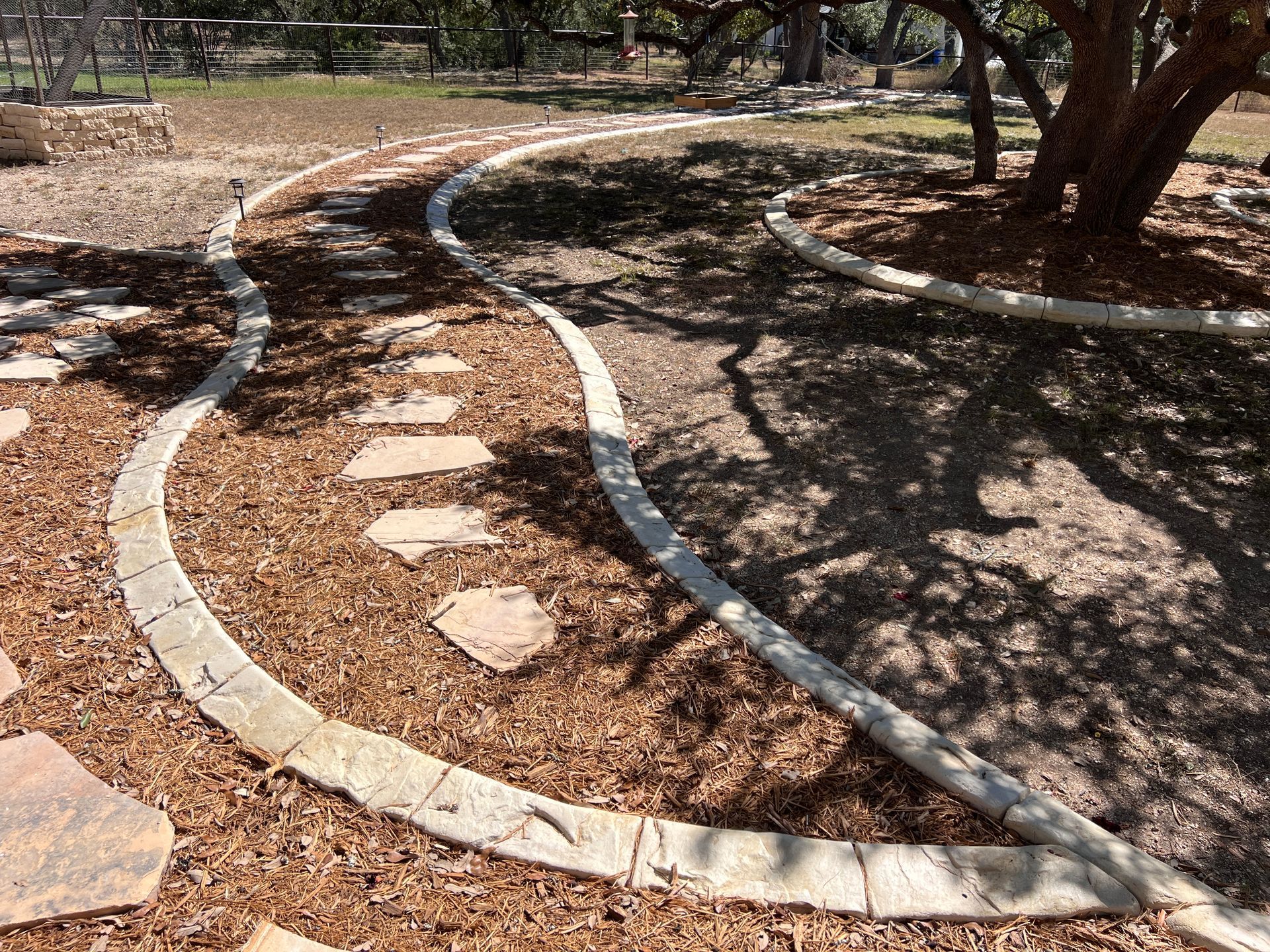 A concrete walkway in a park with a tree in the background.