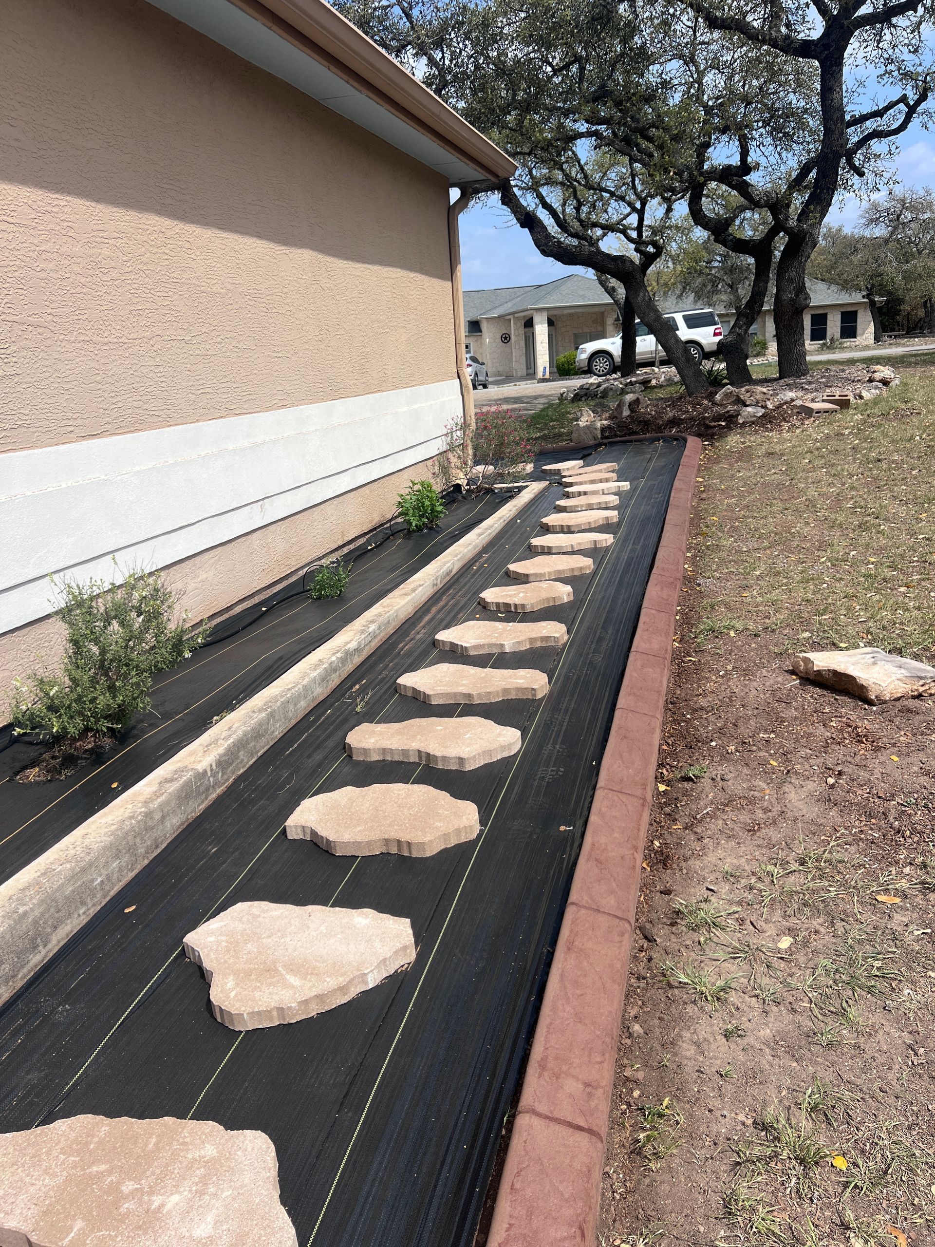 A walkway with stepping stones leading to a house