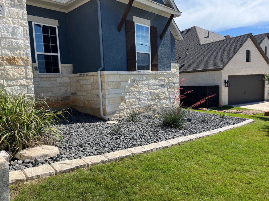 A blue house with a garage and a lawn in front of it.
