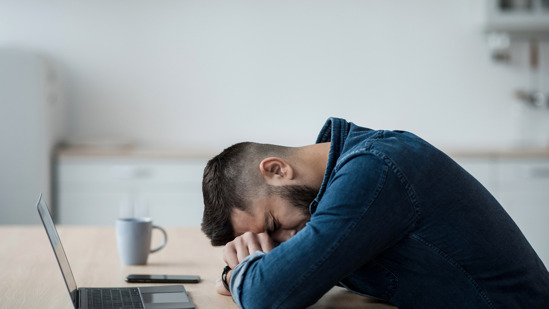 man with head on desk