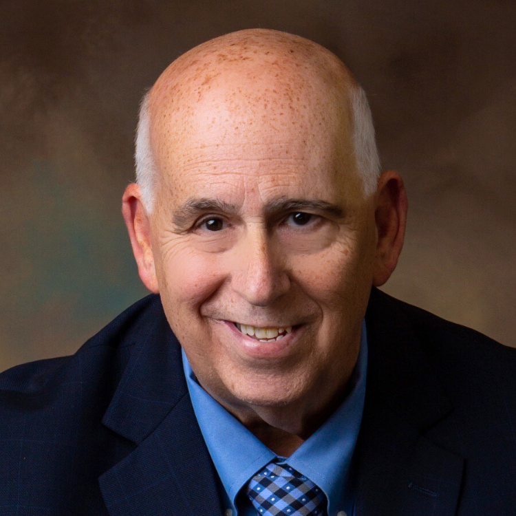 Agency owner Jack DeLuca in a suit and tie is smiling for the camera.