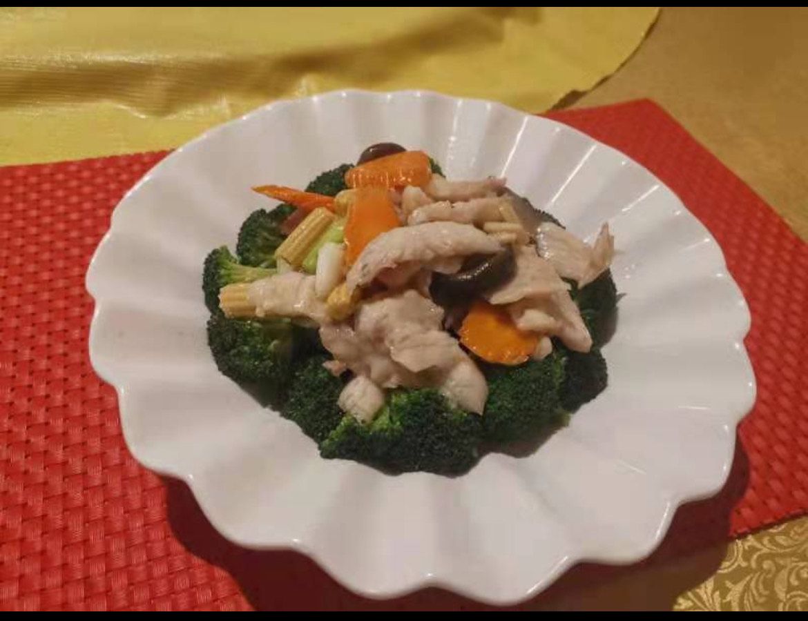 A Plate of Food on a Wooden Table — Red Lantern Chinese Restaurant In Palmerston City, NT