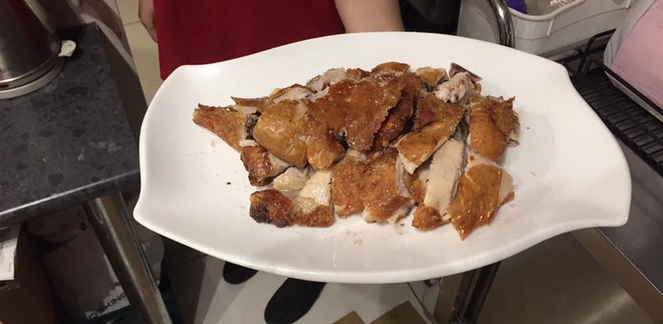 A Person is Holding a Plate of Food in a Kitchen — Red Lantern Chinese Restaurant In Palmerston City, NT