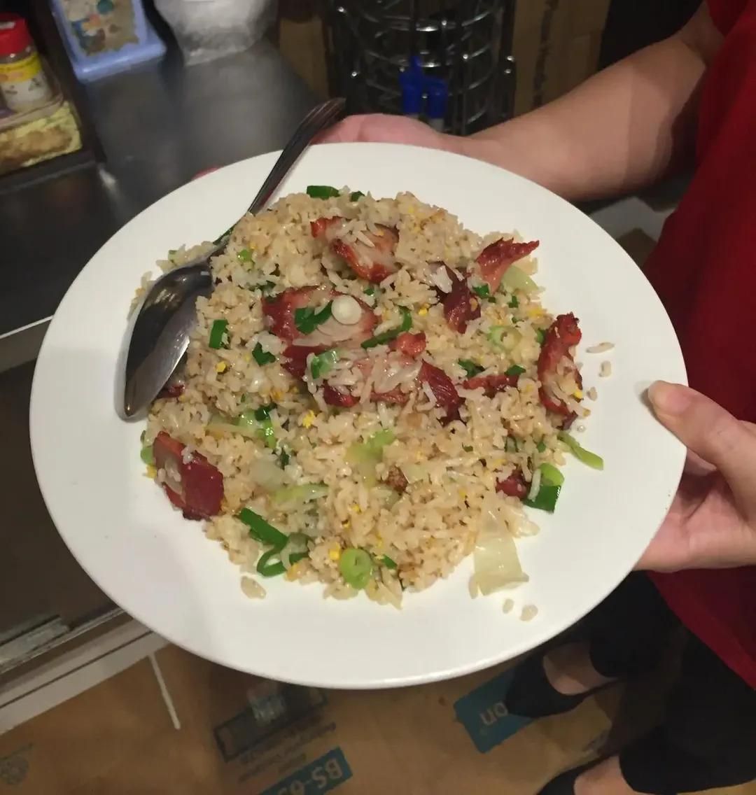 A Person is Holding a Plate of Food With a Spoon on It — Red Lantern Chinese Restaurant In Palmerston City, NT
