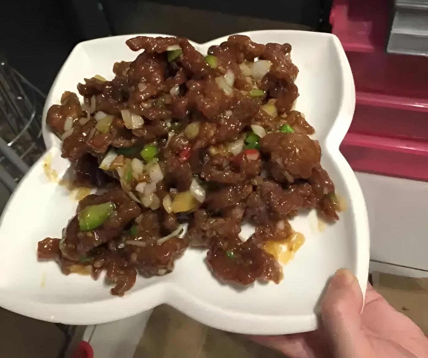 A Person is Holding a White Plate With Meat on It — Red Lantern Chinese Restaurant In Palmerston City, NT