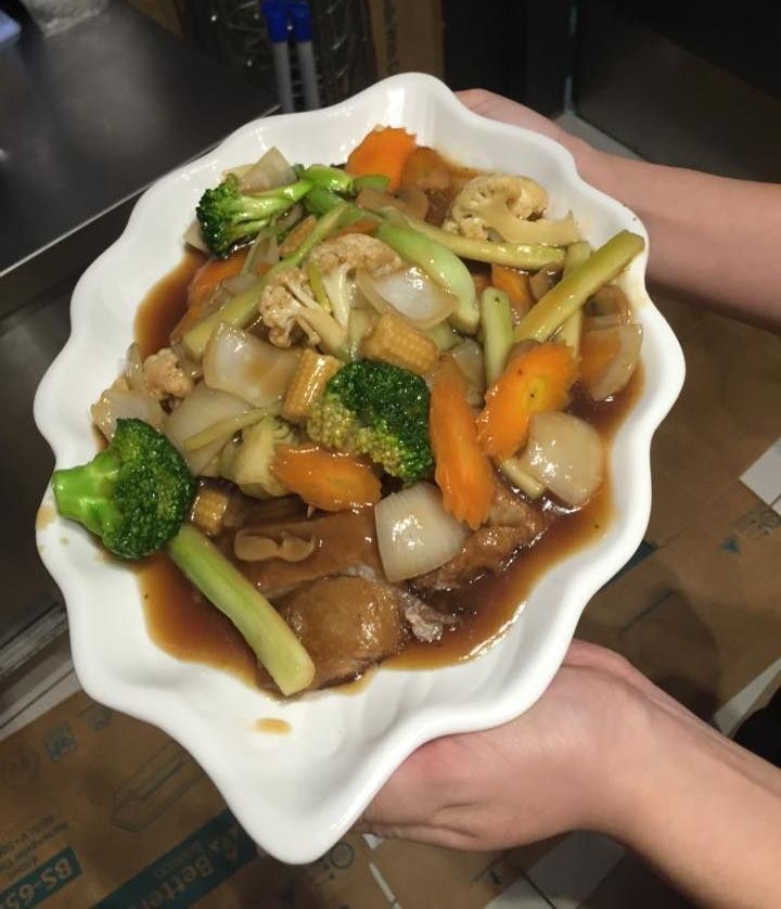 A Person is Holding a Plate of Food in Their Hand — Red Lantern Chinese Restaurant In Palmerston City, NT
