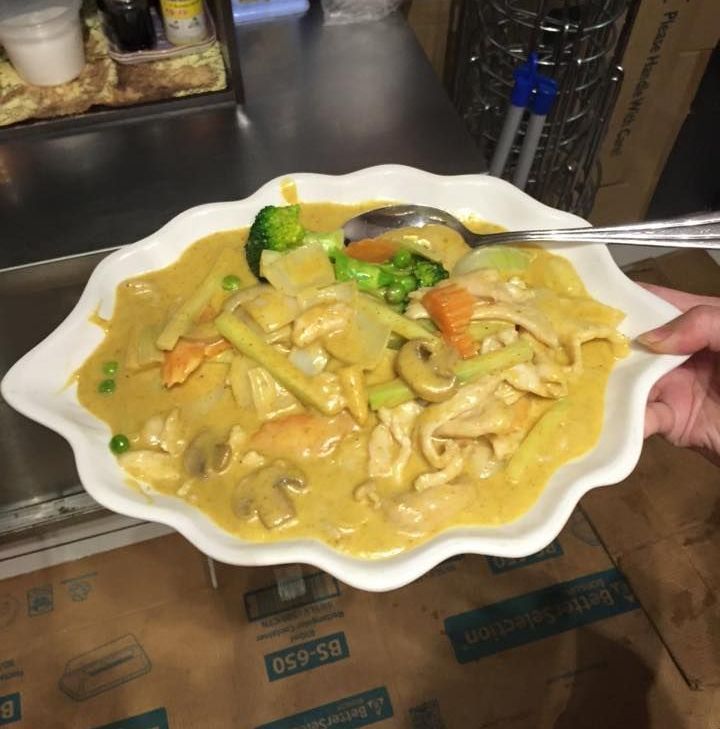 A Person is Holding a Plate of Food With a Spoon in It — Red Lantern Chinese Restaurant In Palmerston City, NT