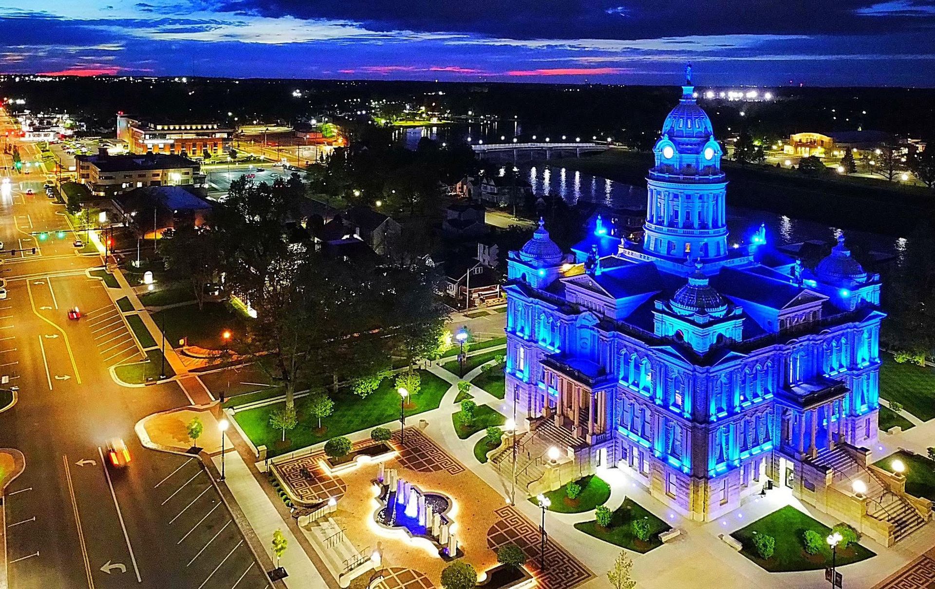 Wooden bridge over a trail in a sunny, green forest.