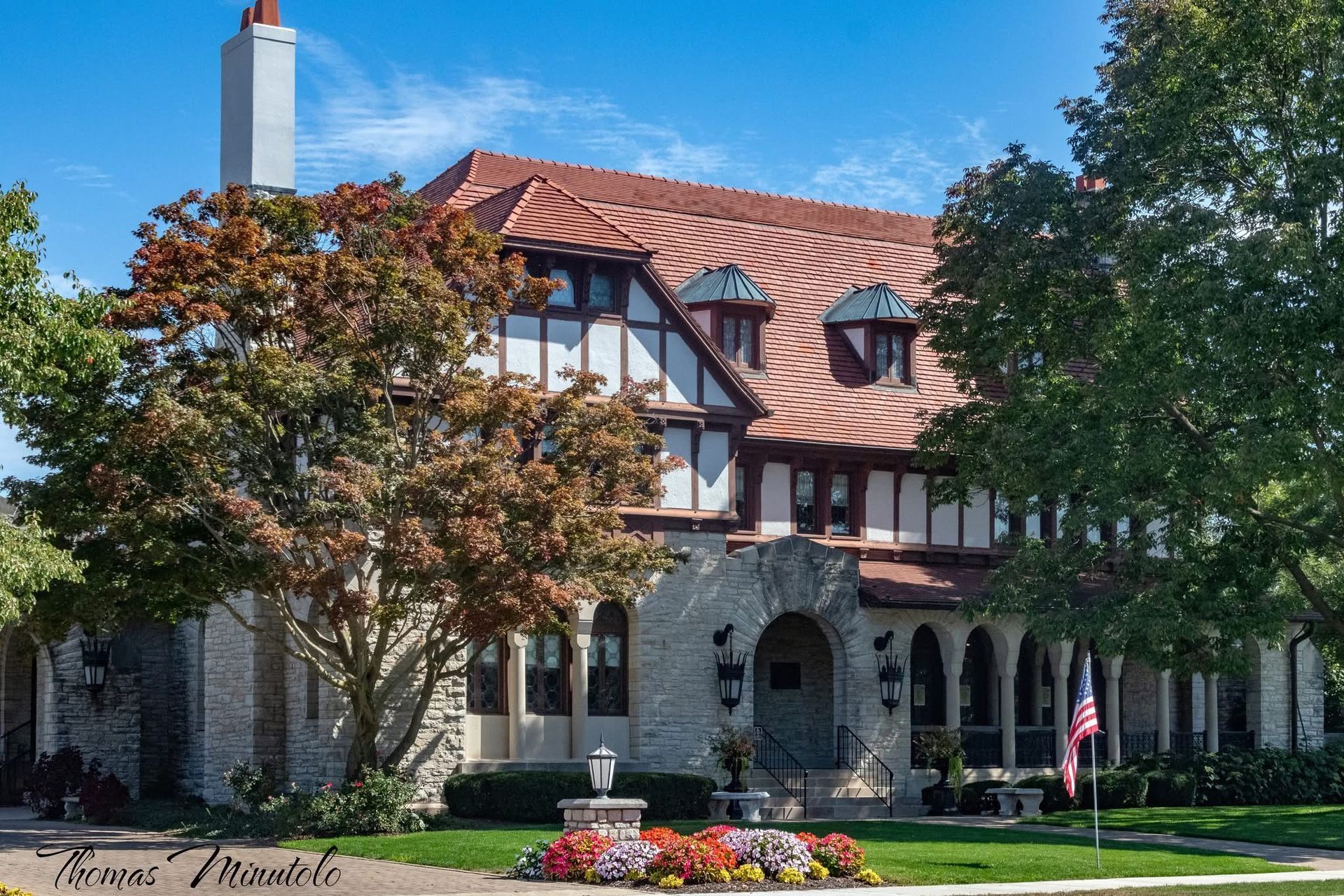 Hands fold a blue and white star-spangled portion of an American flag, as part of a formal folding ceremony.