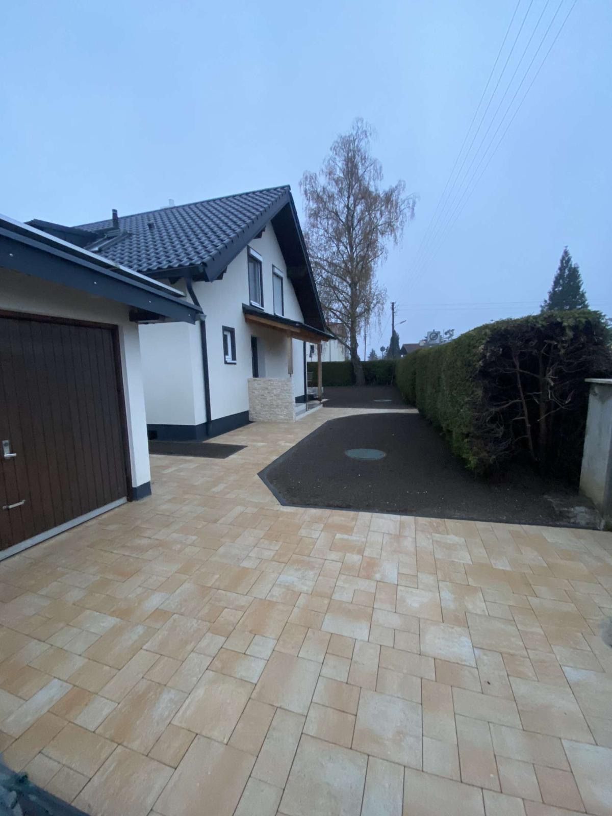 Ein Haus mit einer Garage und einer Auffahrt davor