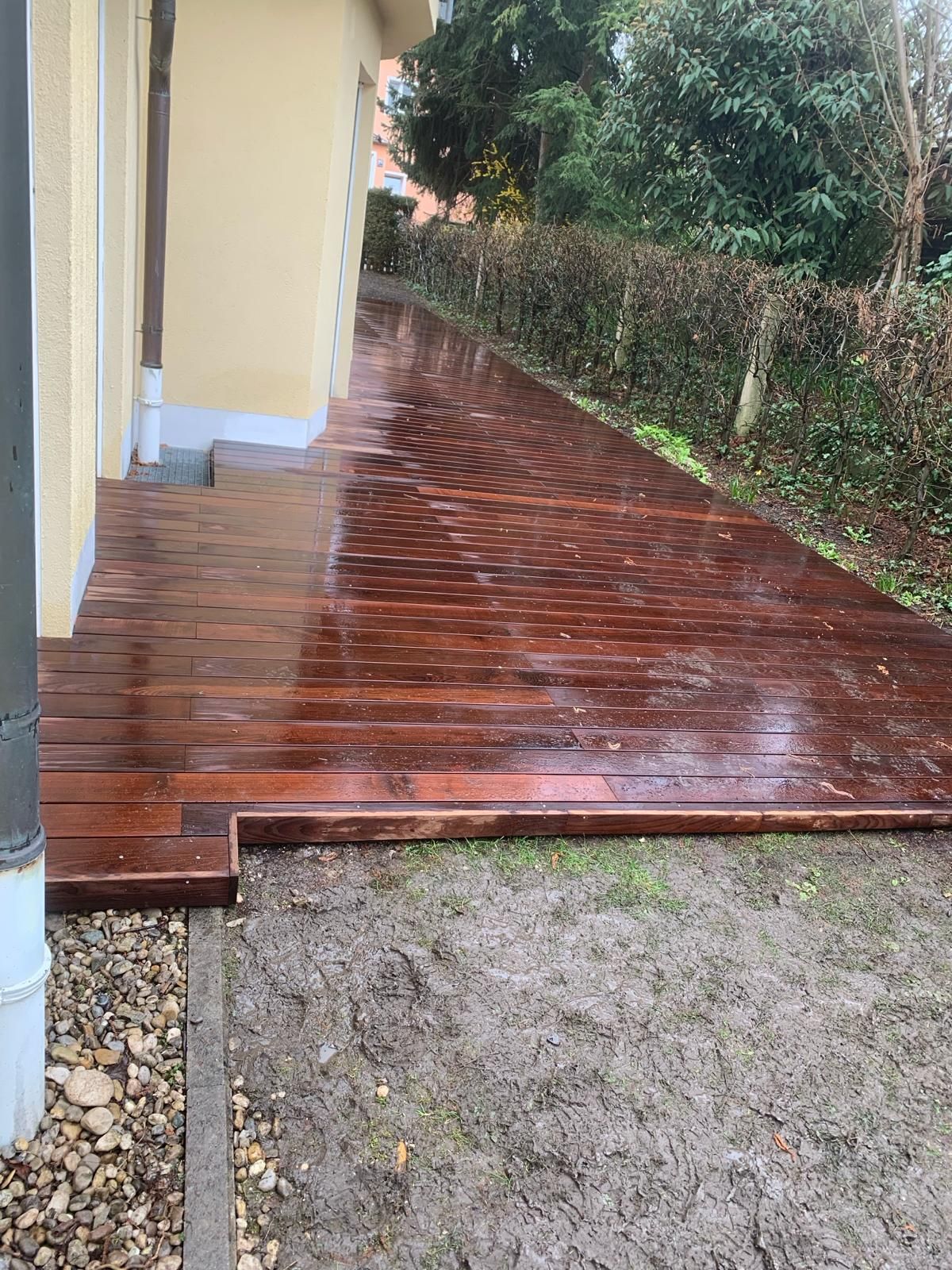 Im Hinterhof eines Hauses wird eine Holzterrasse gebaut.