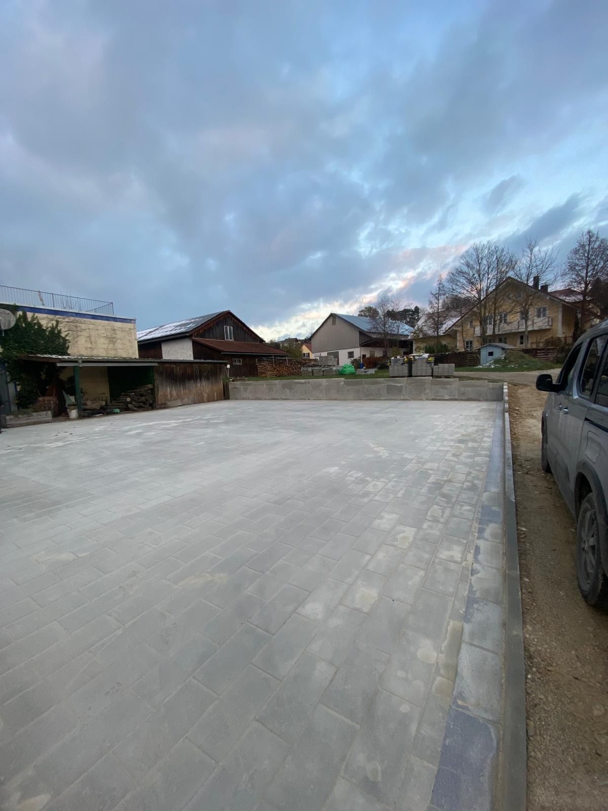 Ein Auto steht mitten auf einem Betonparkplatz.