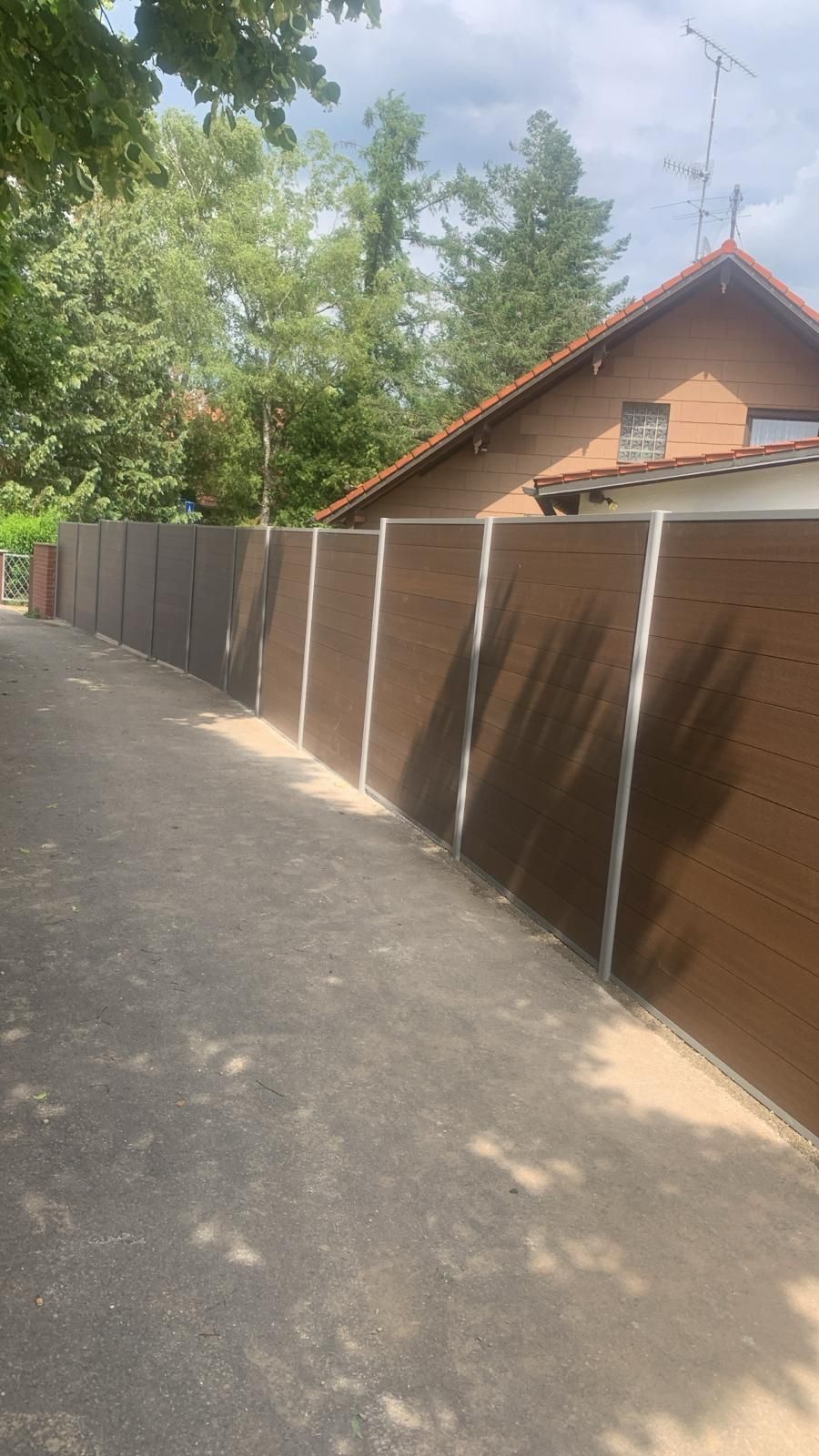 Ein Zaun am Straßenrand neben einem Haus.