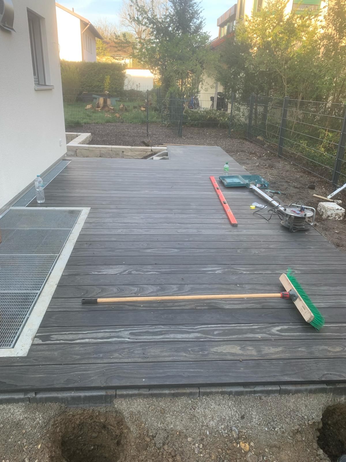 Ein Holzdeck mit einem Besen und einer Wasserwaage darauf.