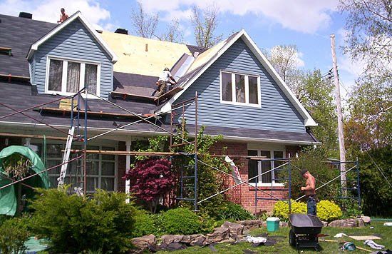 Un homme travaille sur le toit d'une maison.