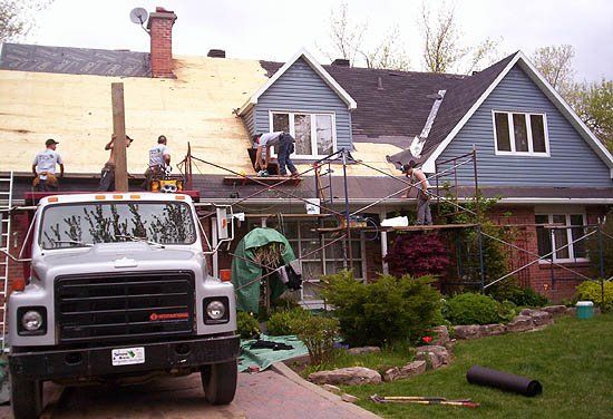 Un camion est garé devant une maison en cours de rénovation.