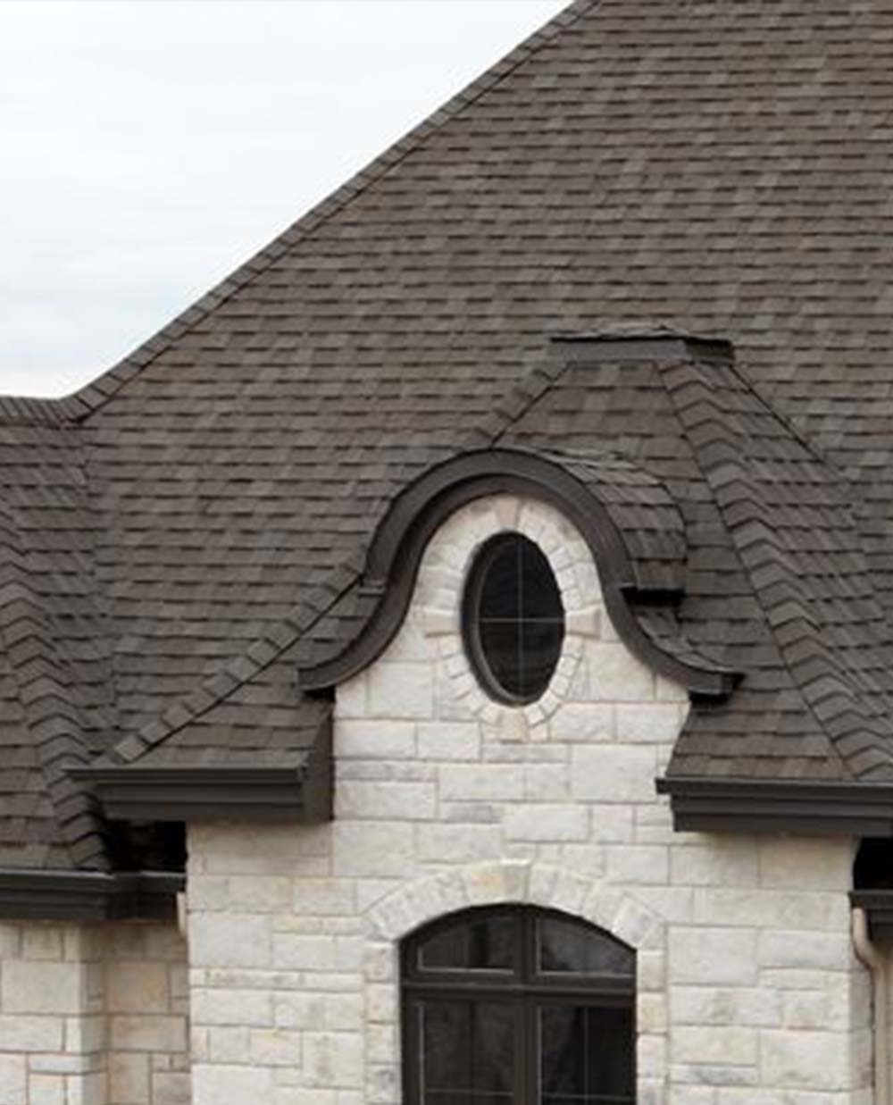 Une maison avec un toit gris et une fenêtre ronde