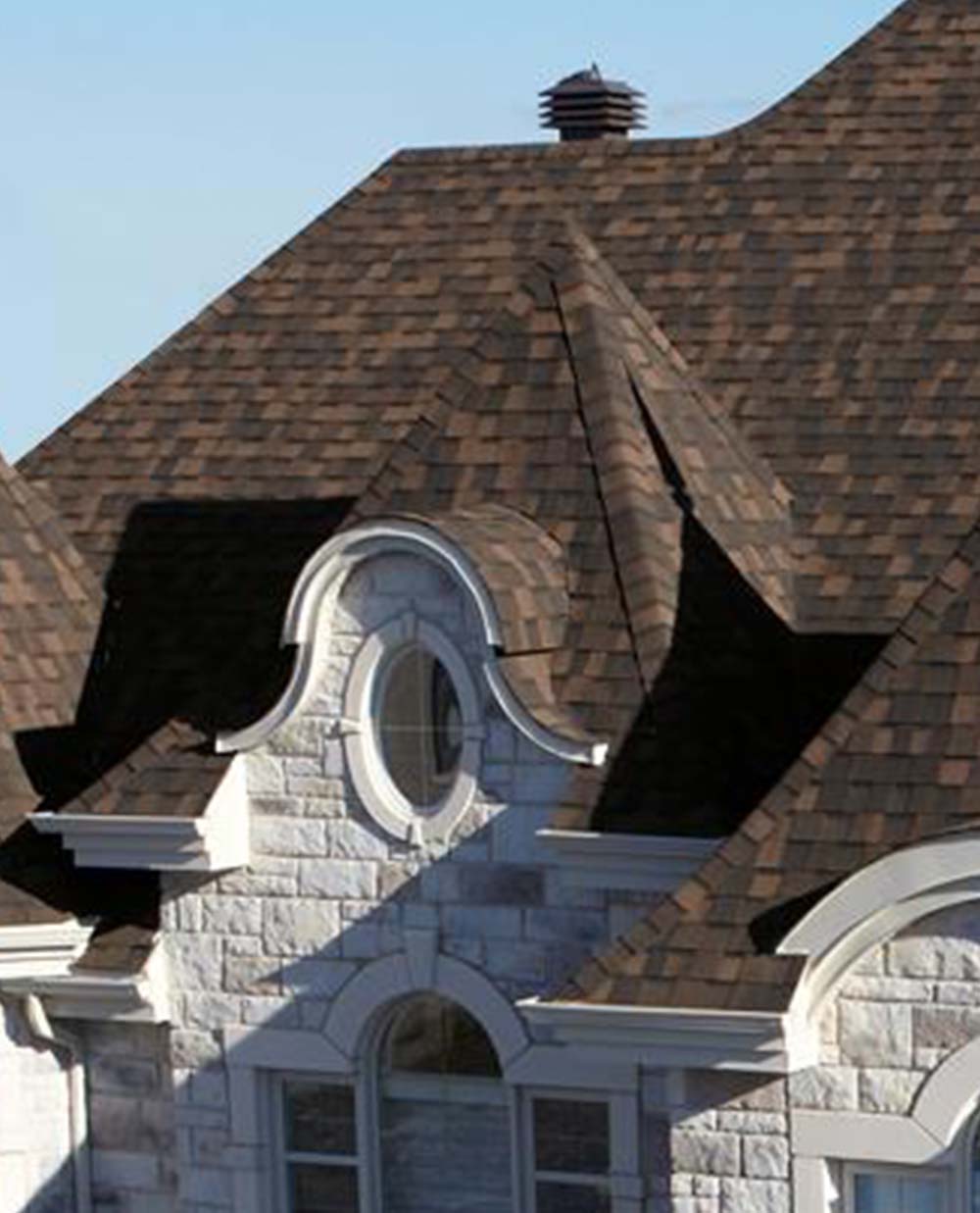 Un bâtiment en brique avec un toit marron et une fenêtre ronde