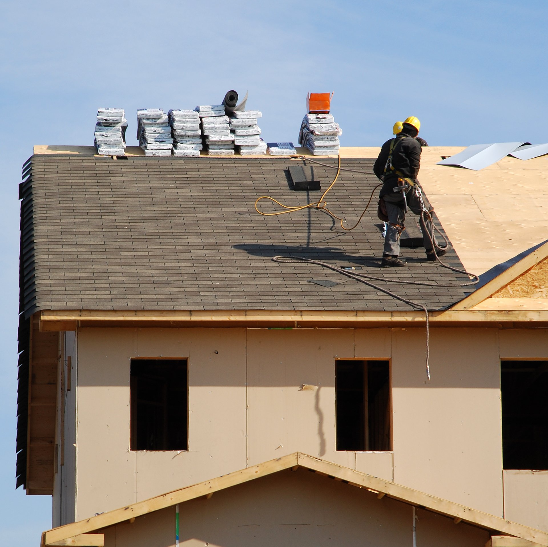 Deux hommes travaillent sur le toit d'une maison