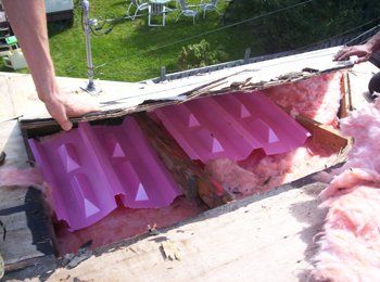 Une personne travaille sur un toit avec un toit rose