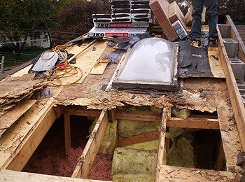 Un homme travaille sur le toit d'une maison