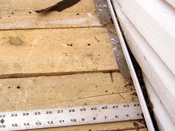Une règle blanche est posée sur une surface en bois