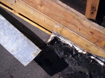 Un morceau de métal est posé sur le sol à côté d'un morceau de bois.