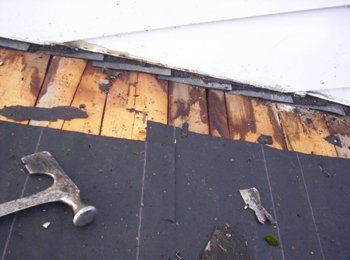 Un marteau et une spatule sont posés sur un toit