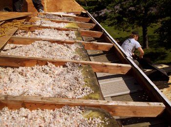 Un homme travaille sur le toit d'une maison.