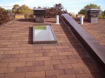 Un toit avec une lucarne et des cheminées dessus