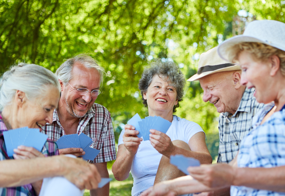 Seniors enjoying a sunny summer day at a retirement residence in Joliette, sitting outdoors, smiling and chatting together.