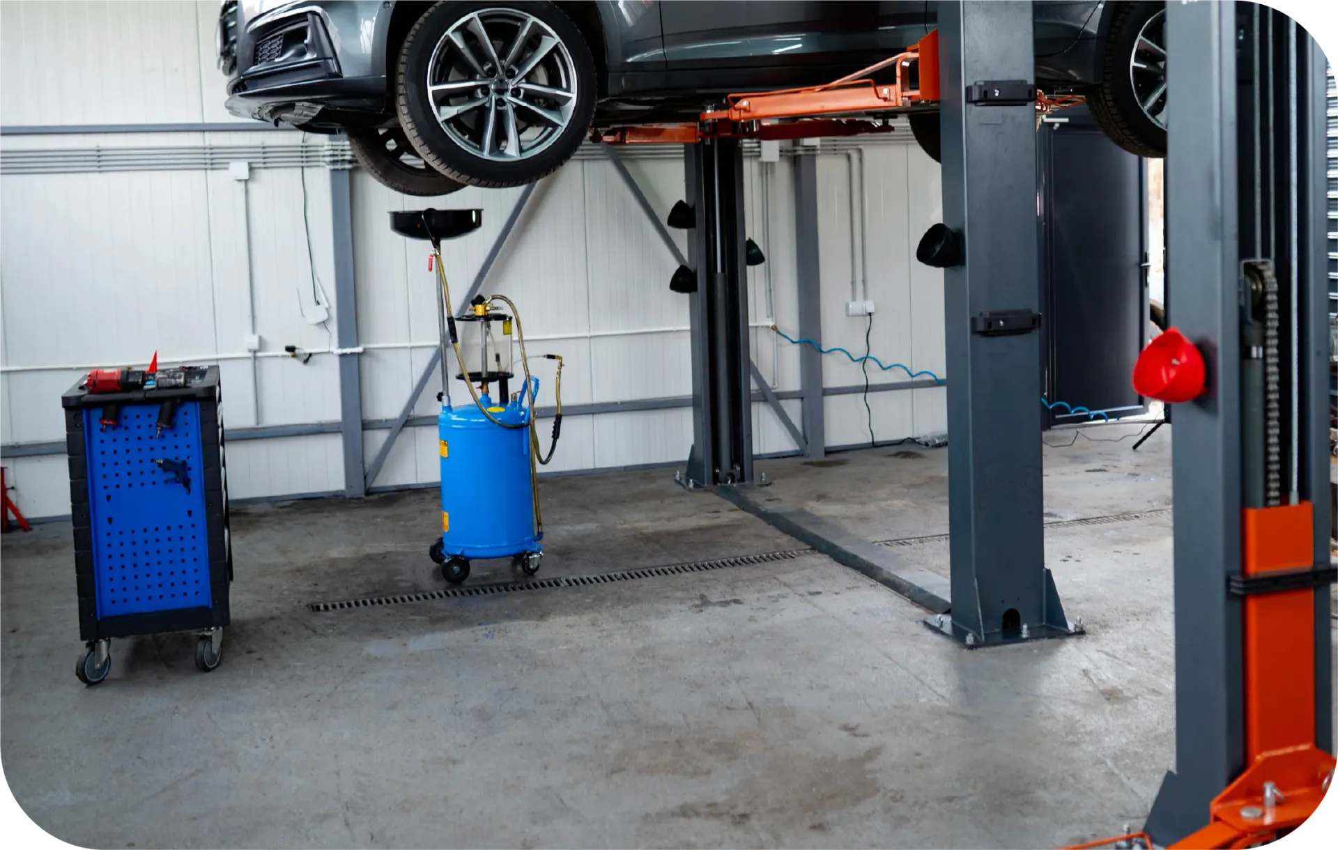 A car is sitting on a lift in a garage.