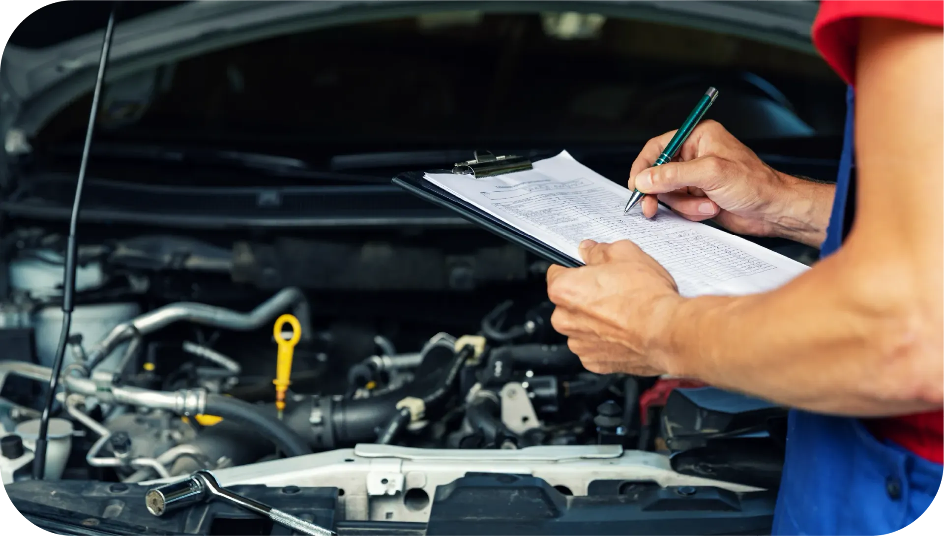 A man is writing on a clipboard while looking under the hood of a car.