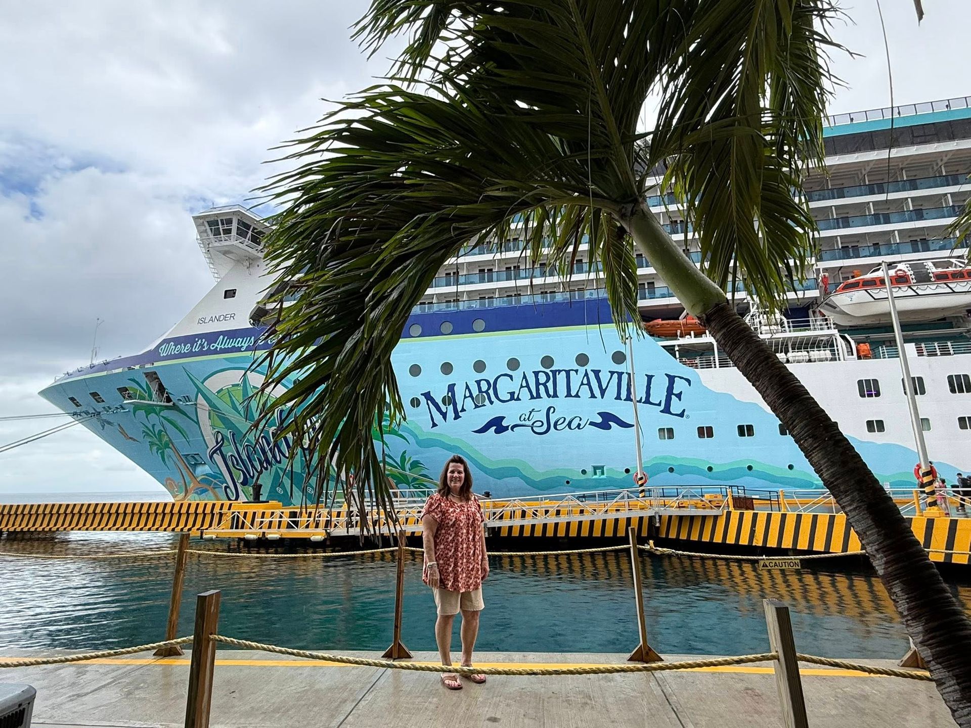 Person with backpack walking down a narrow street lined with buildings.