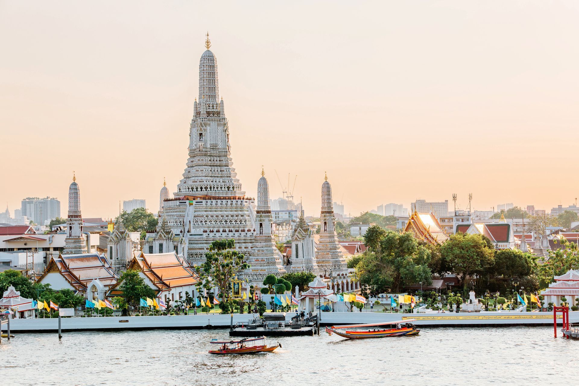 Wat Arun temple in Bangkok, Thailand, reflected in the Chao Phraya River at sunset.