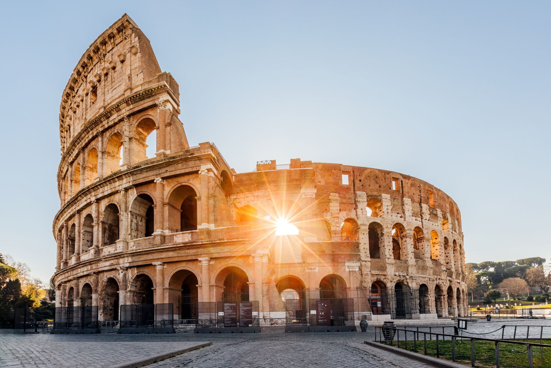 Colosseum in Rome, Italy, with the sun shining through its arches.