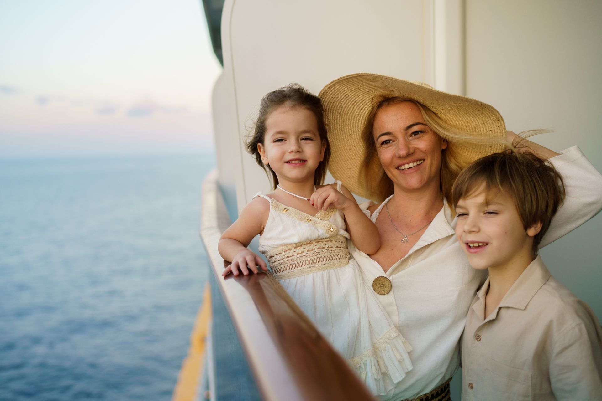 People jumping off a white boat into clear blue water on a sunny day.