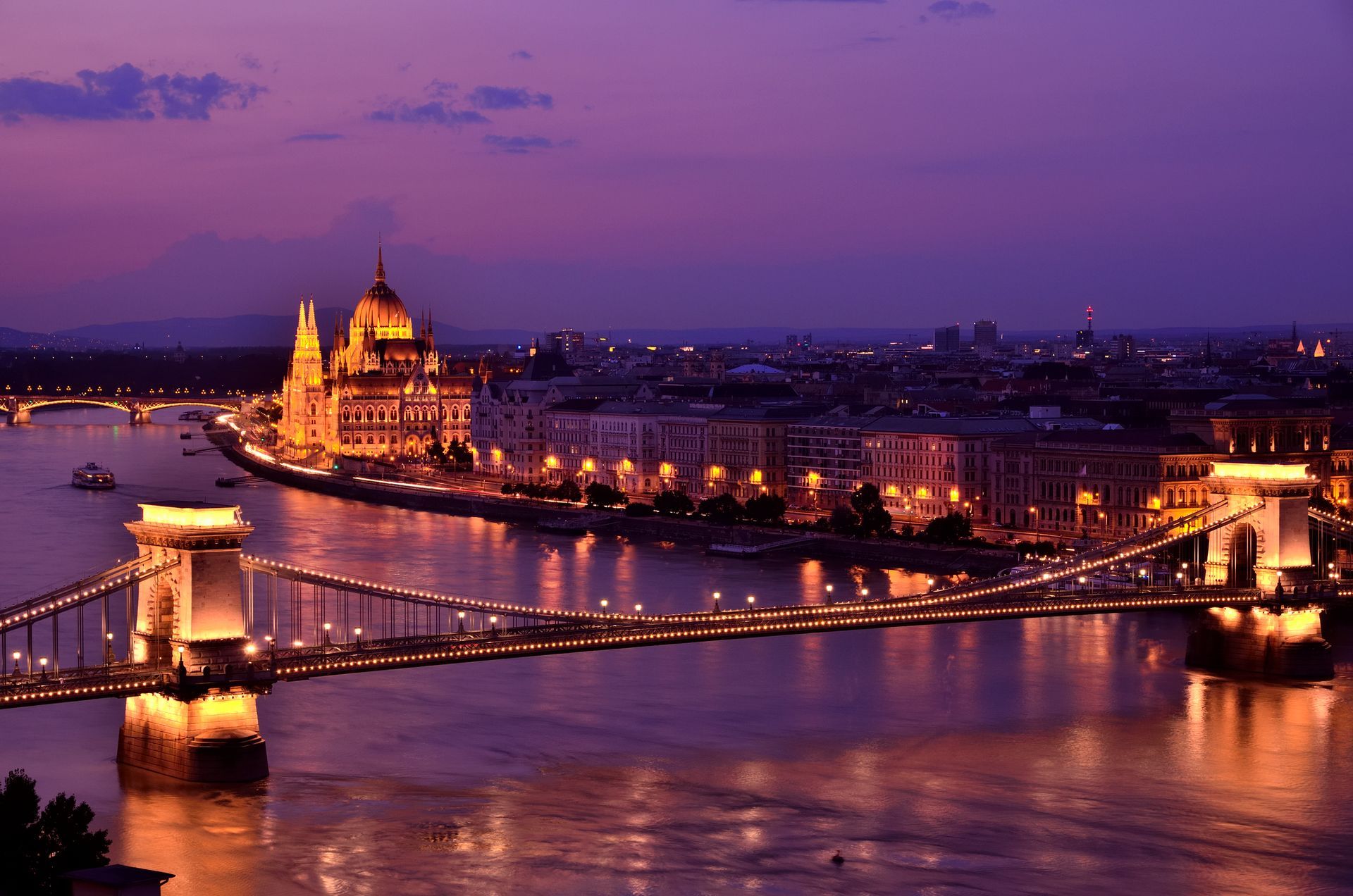 Outdoor dining table on a yacht, set with blue glassware and floral arrangement. Bright turquoise cushions, ocean background.