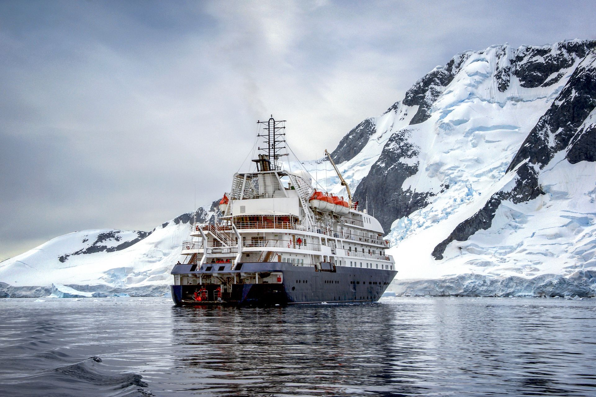 Cruise ship sailing near icy mountains.
