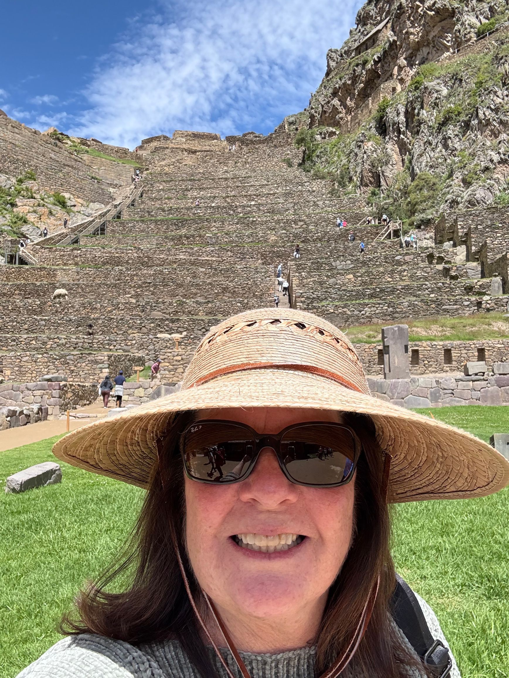Laptop with blank screen, passport, ticket, map, and sunglasses on a wooden surface.