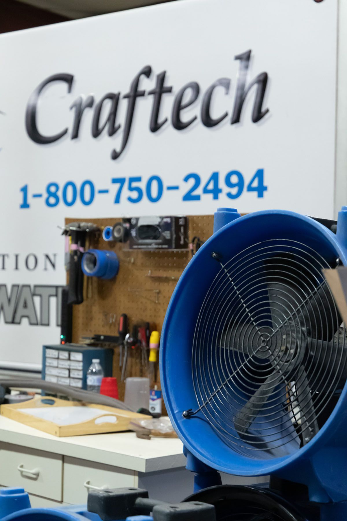 Blue fan in front of a sign for