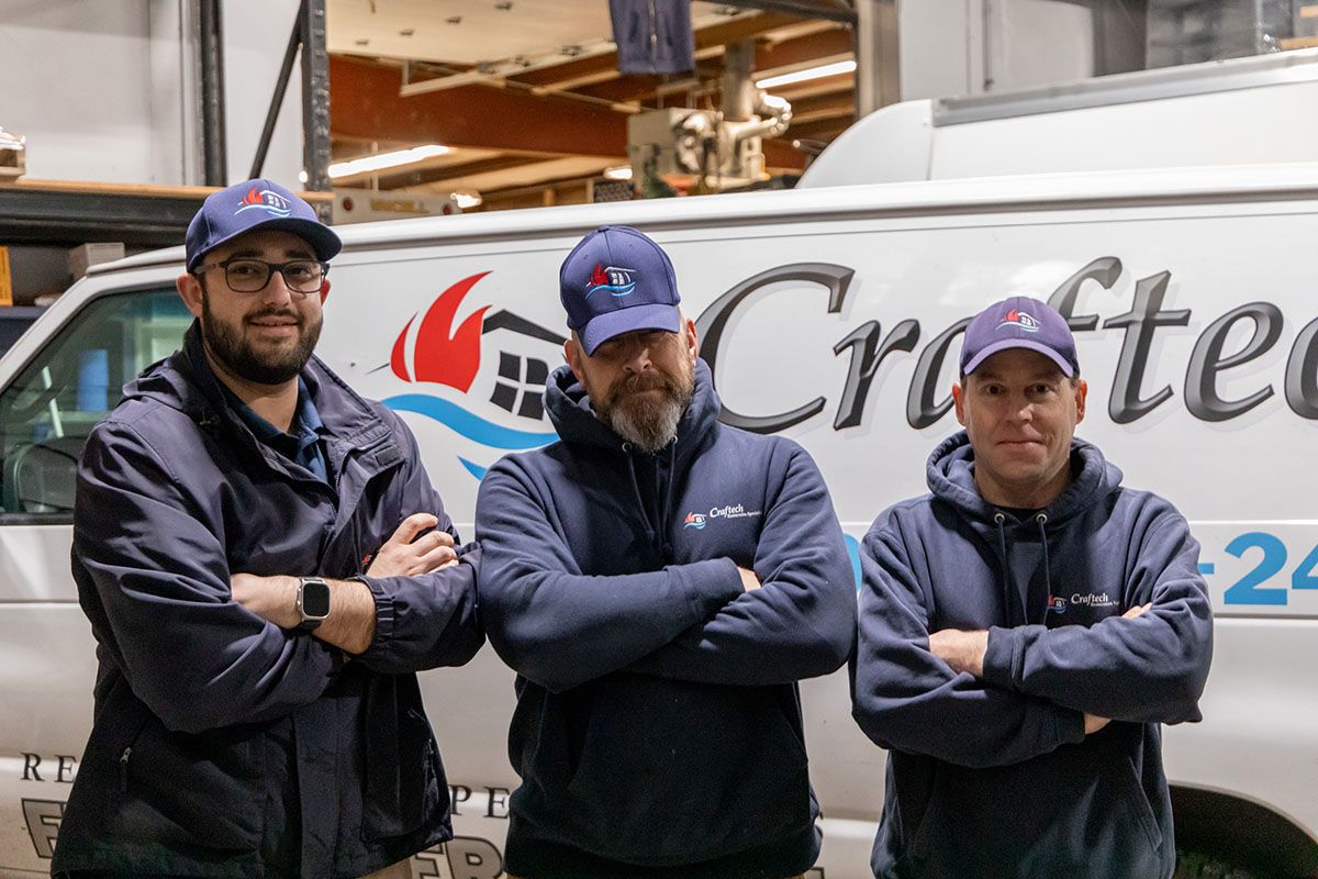 Three men are posing for a picture in front of a crafter van.