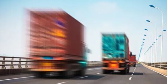 A blurry picture of trucks driving down a highway