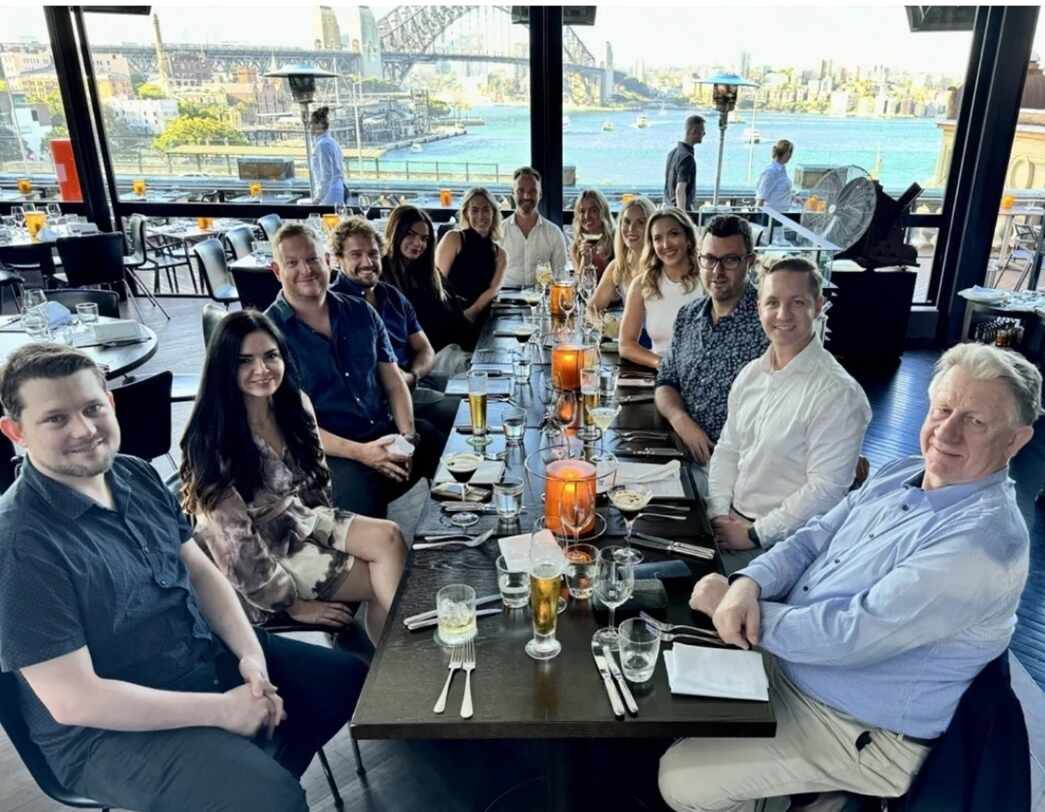 A group of people are sitting at a long table in a restaurant