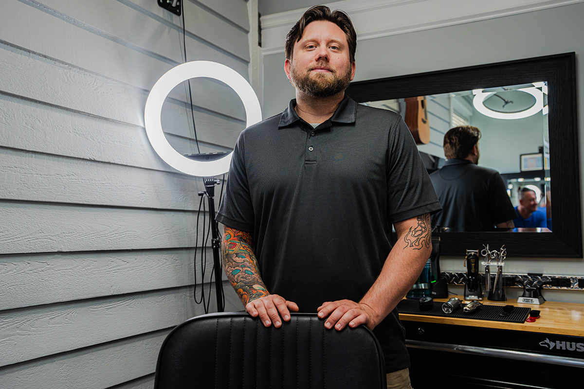Two women are kneeling on the beach and hugging each other.