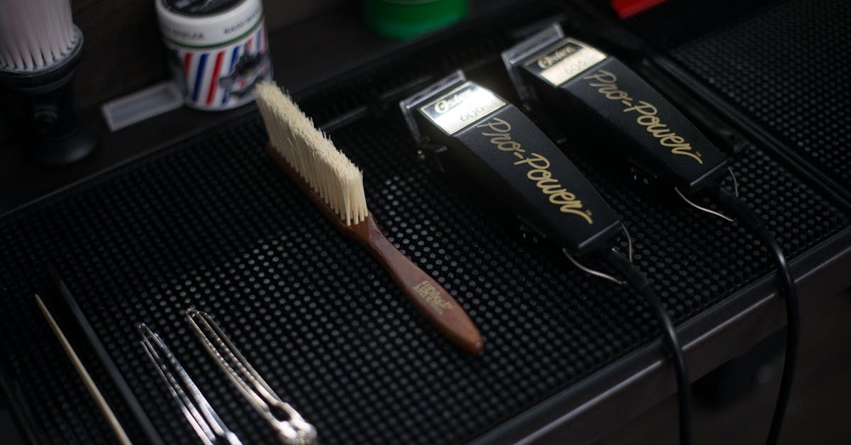 Three shaving machines are sitting on top of a black mat.