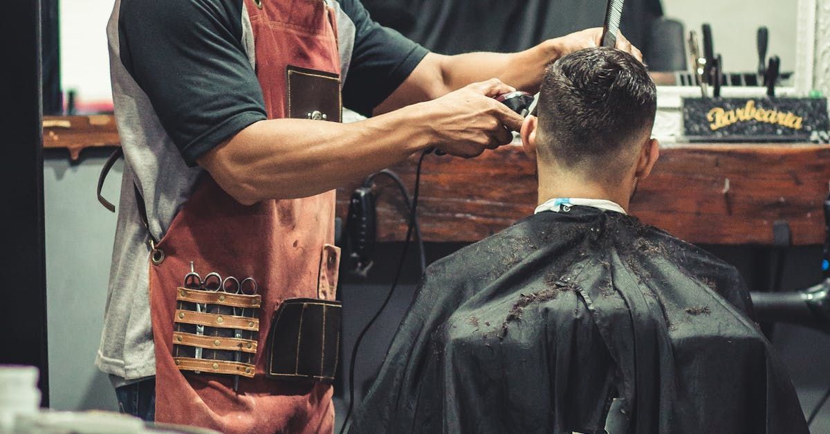 A man is getting his hair cut by a barber in a barber shop.